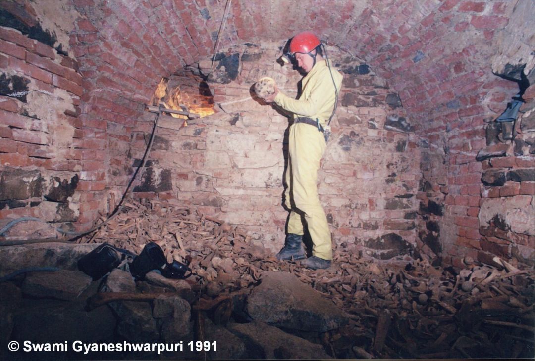 Ossárium v průběhu vyklízení kostí. Na fotografii Marek Šenkyřík, který právě objevil další pomalovanou lebku (1991).